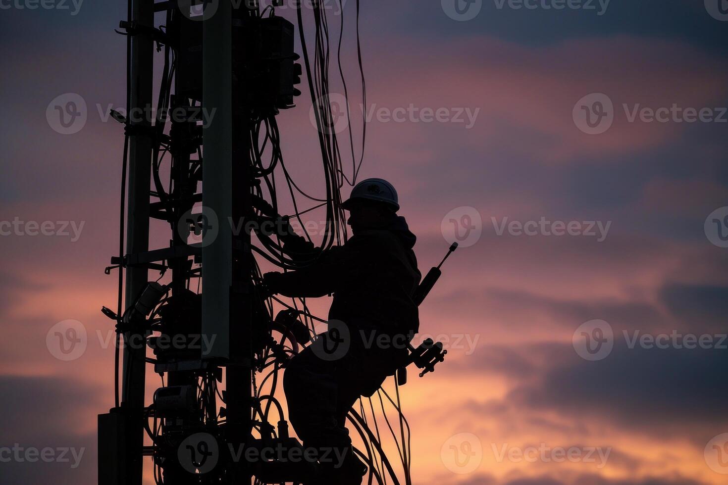 Telecommunications tower engineer performing maintenance at sunset photo