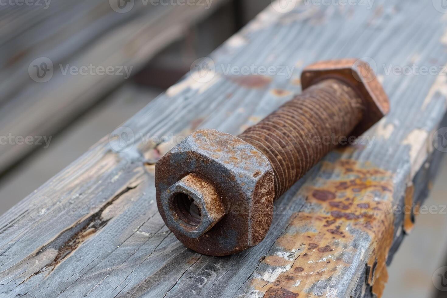 Rusty bolt and nut lying on weathered wooden plank photo