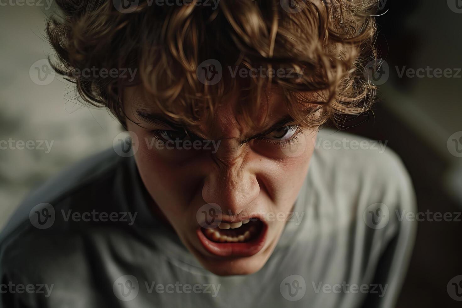Aggressive teenager boy screaming showing negative emotions photo