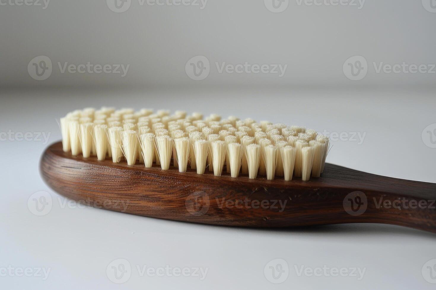 Natural bristle body brush with wooden handle lying on white background photo