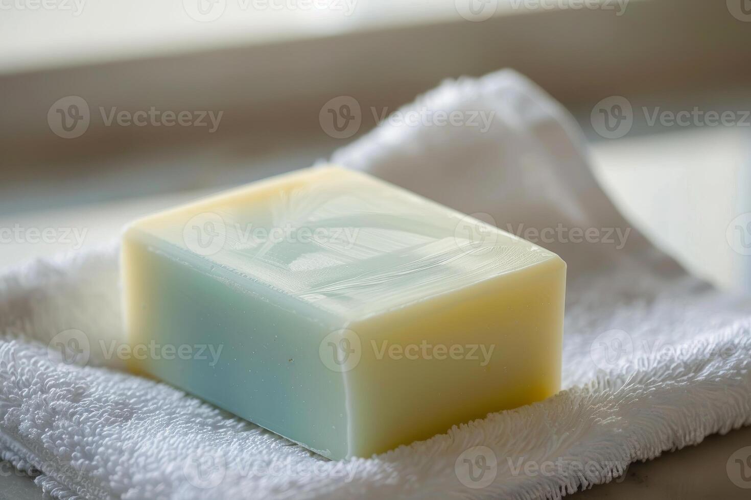 Single bar of soap resting on a white washcloth photo