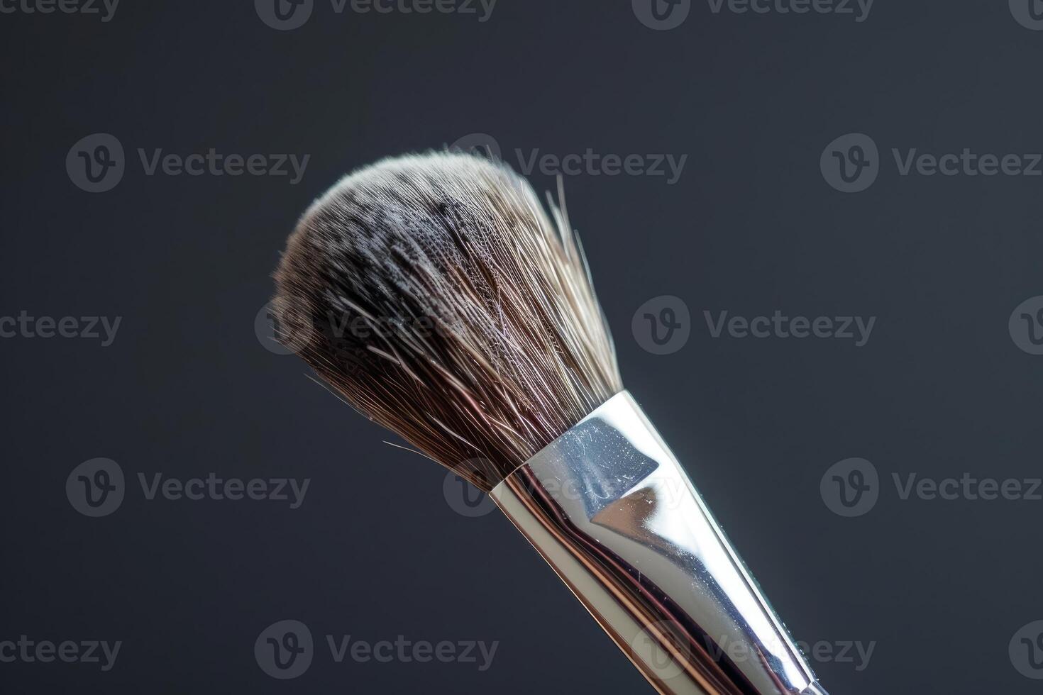 Professional makeup brush standing up on a dark background photo