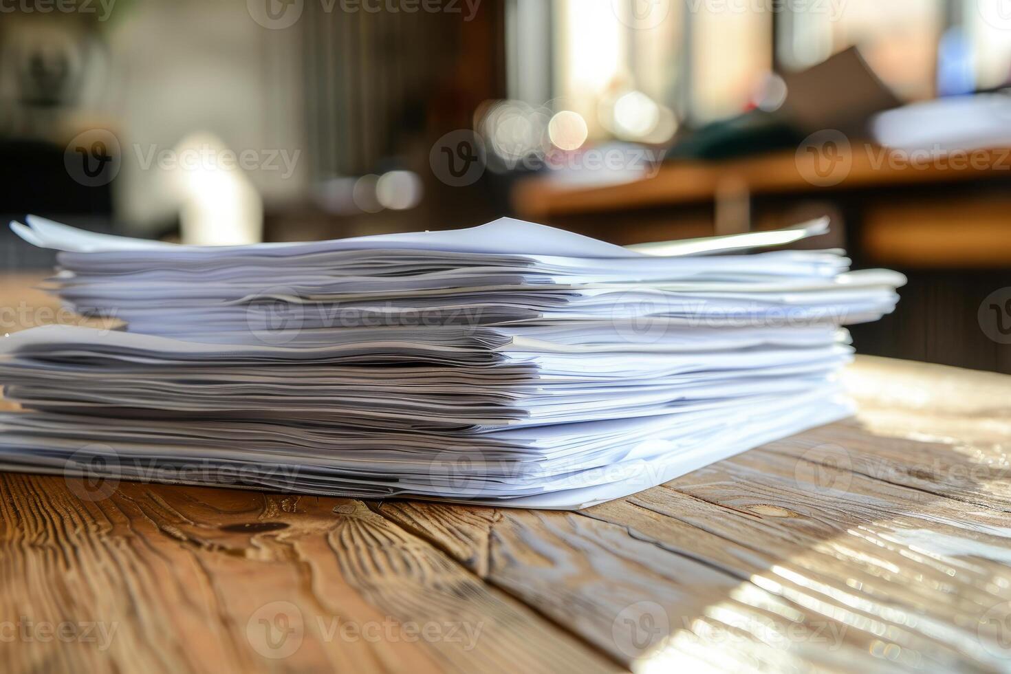 Stack of papers sitting on a wooden table representing lots of work photo