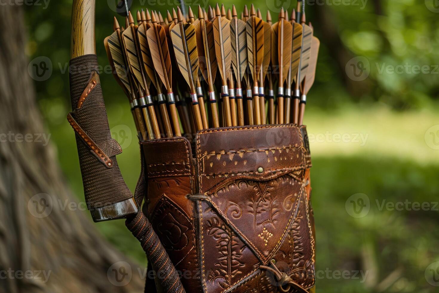 Leather quiver holding arrows is hanging on a tree with bow in a forest photo
