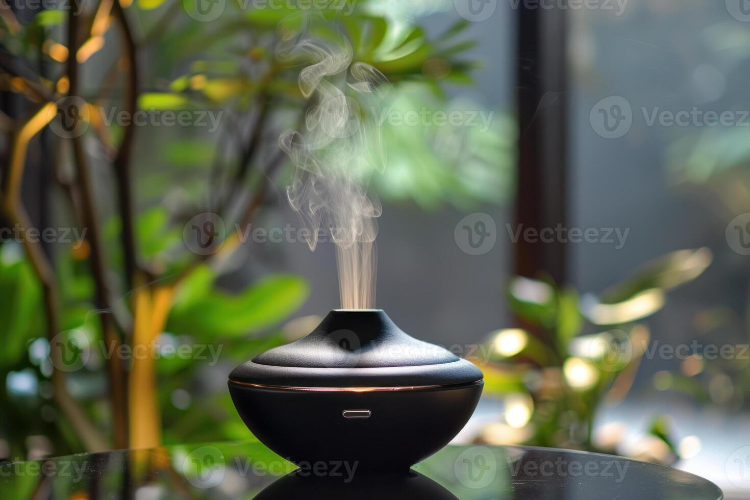 Black aroma diffuser releasing calming fragrance in a green environment photo