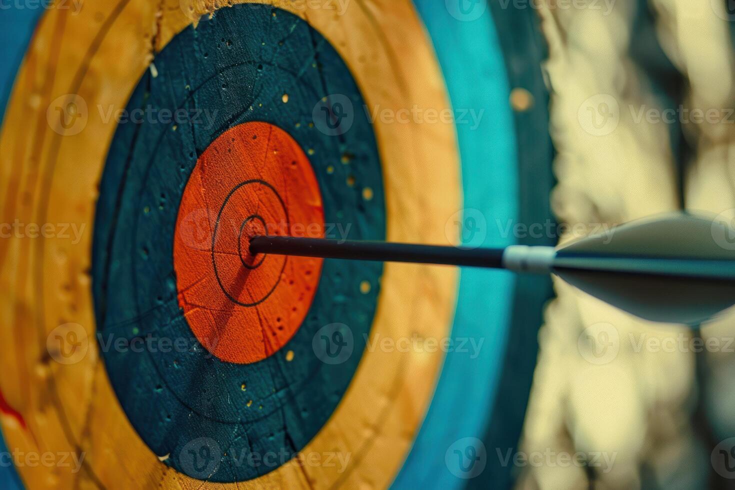 Arrow hitting the center of an archery target on blurred background photo