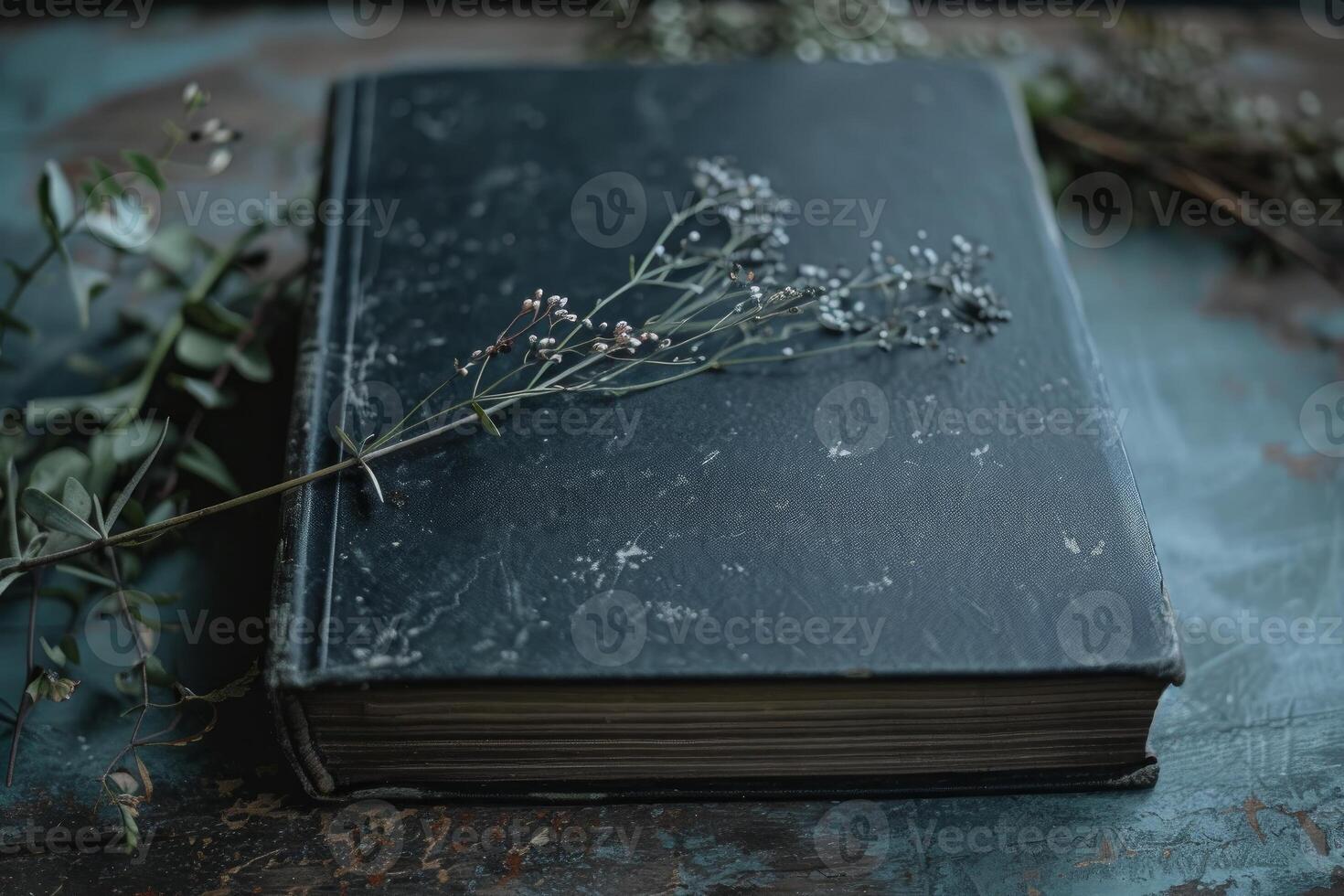 Old weathered book lying on wooden table with flowers photo