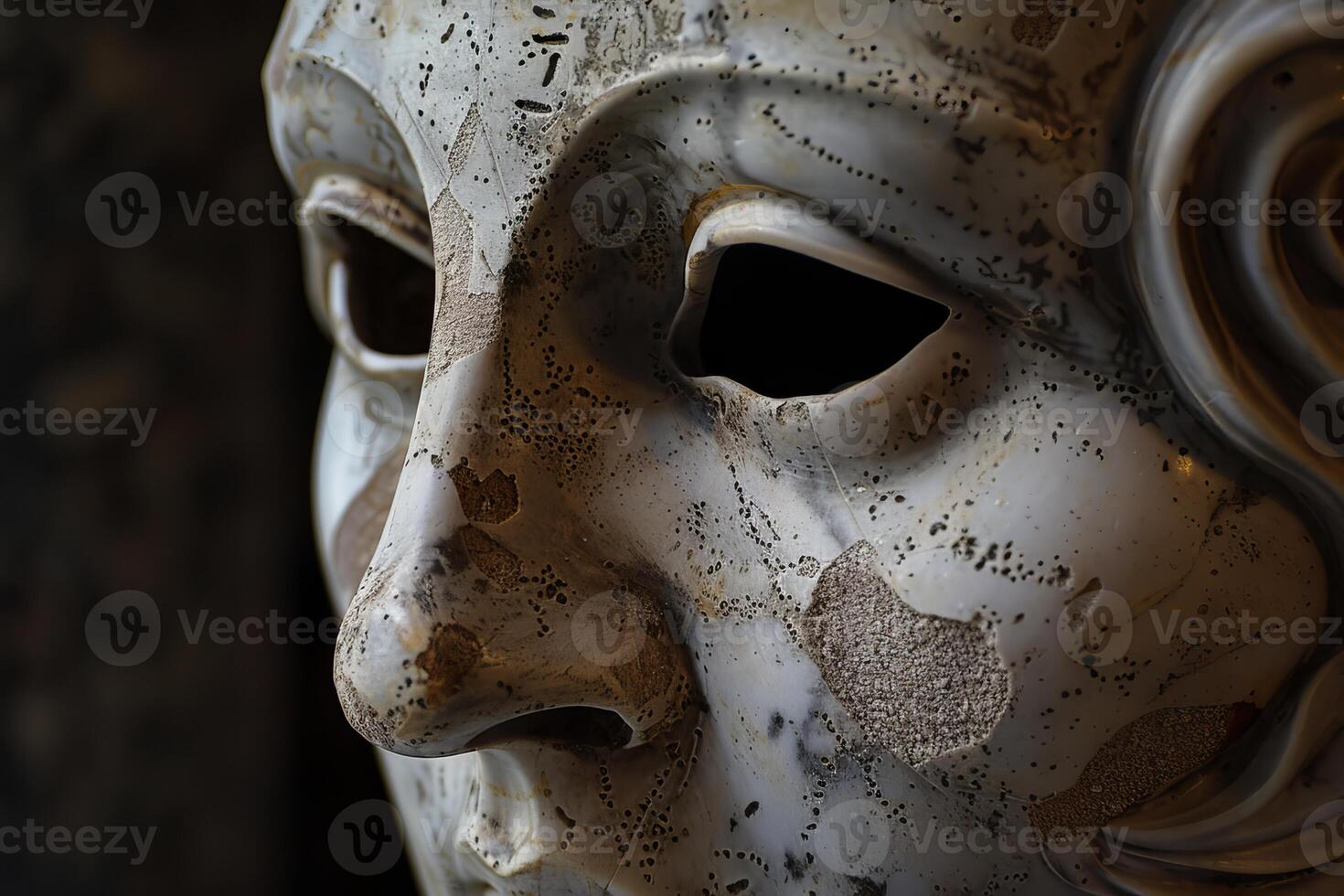 Old cracked stone mask showing the wear of time photo