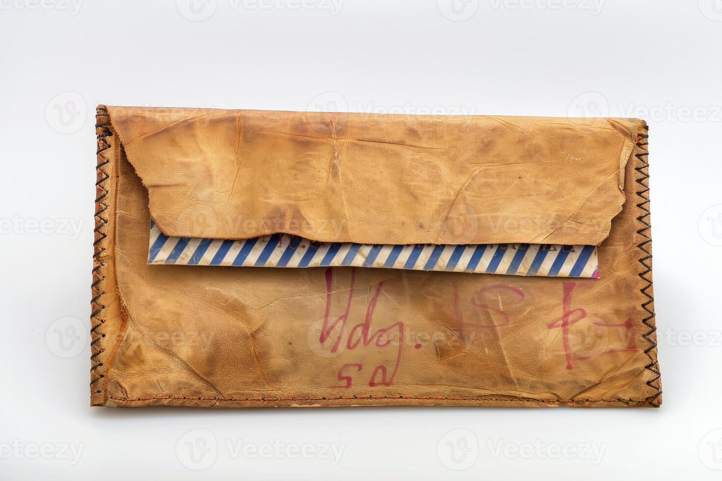 Old leather envelope holding blue and white airmail envelope on white background photo