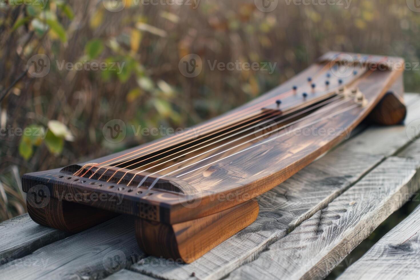 Wooden string instrument gusli resting on rustic table outdoors photo