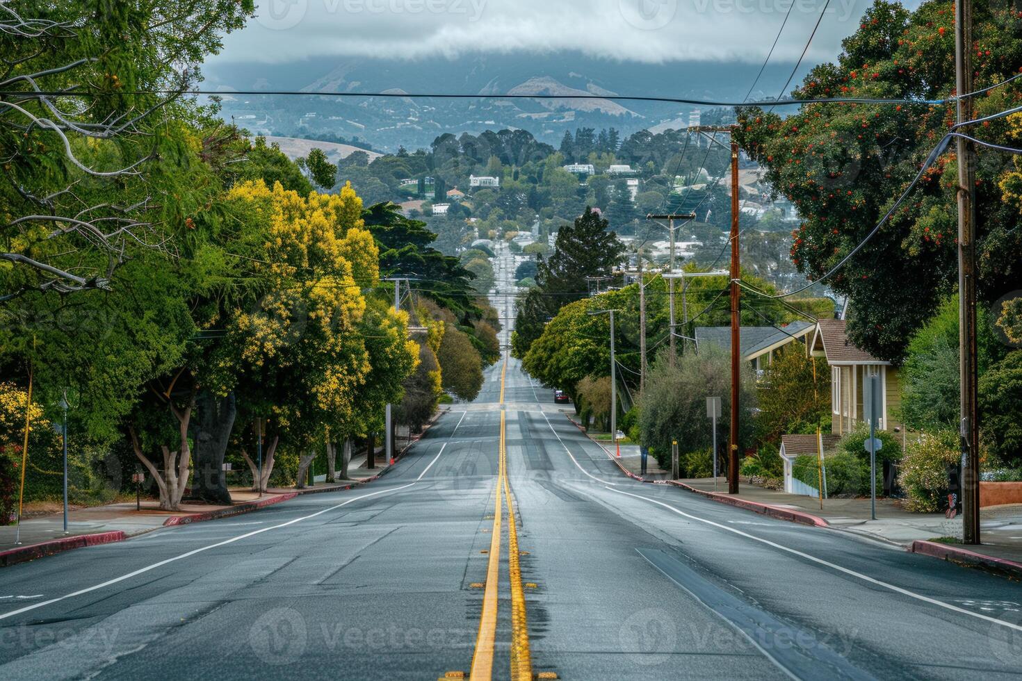 Empty street leading towards the hills on a cloudy day photo