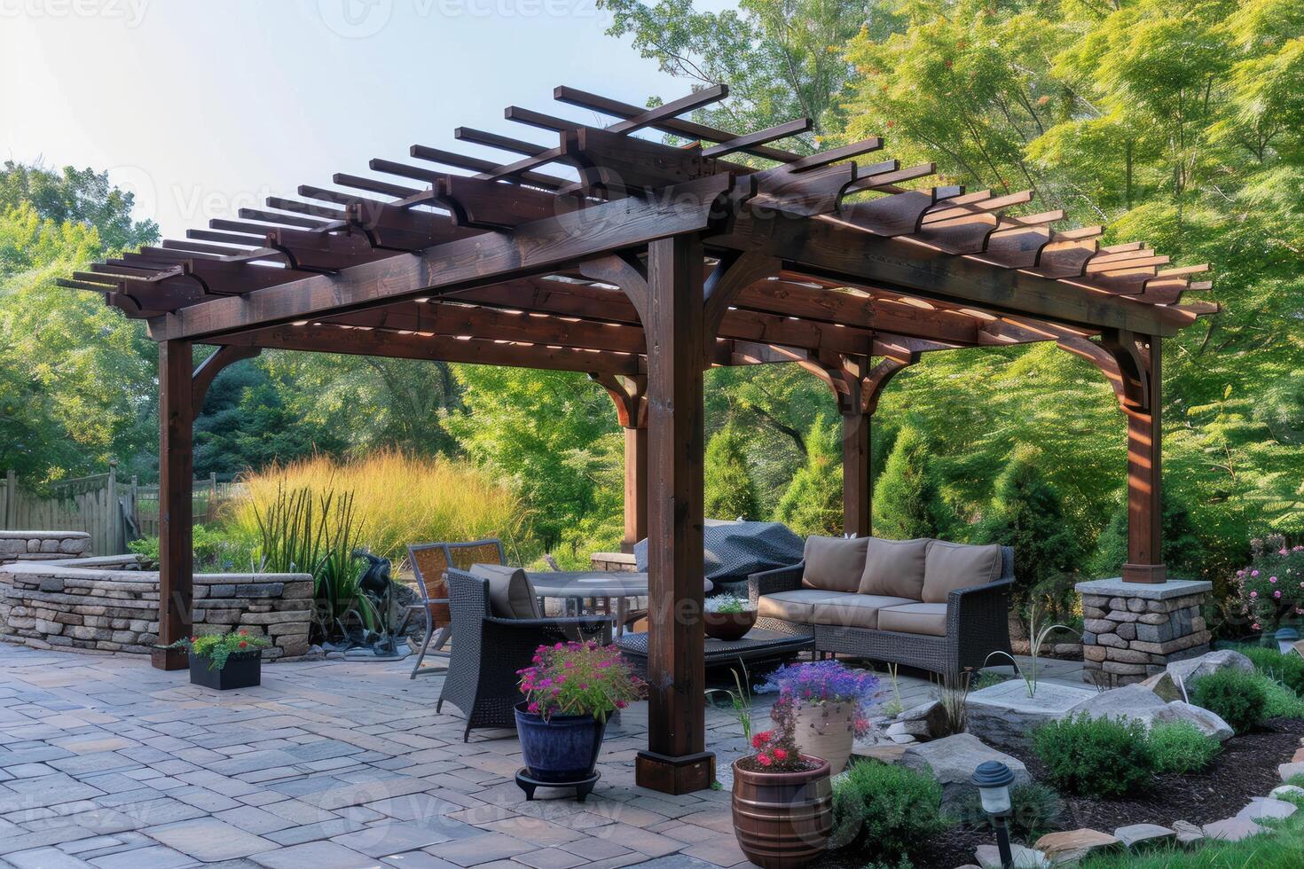 Wooden pergola providing shade on a stone patio in a lush green backyard photo