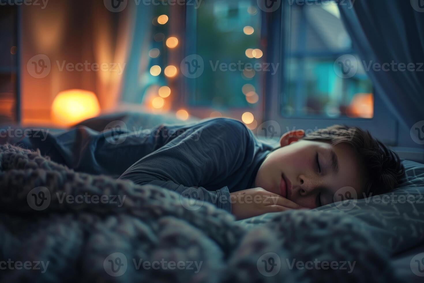 Young boy sleeping peacefully in bed at night photo