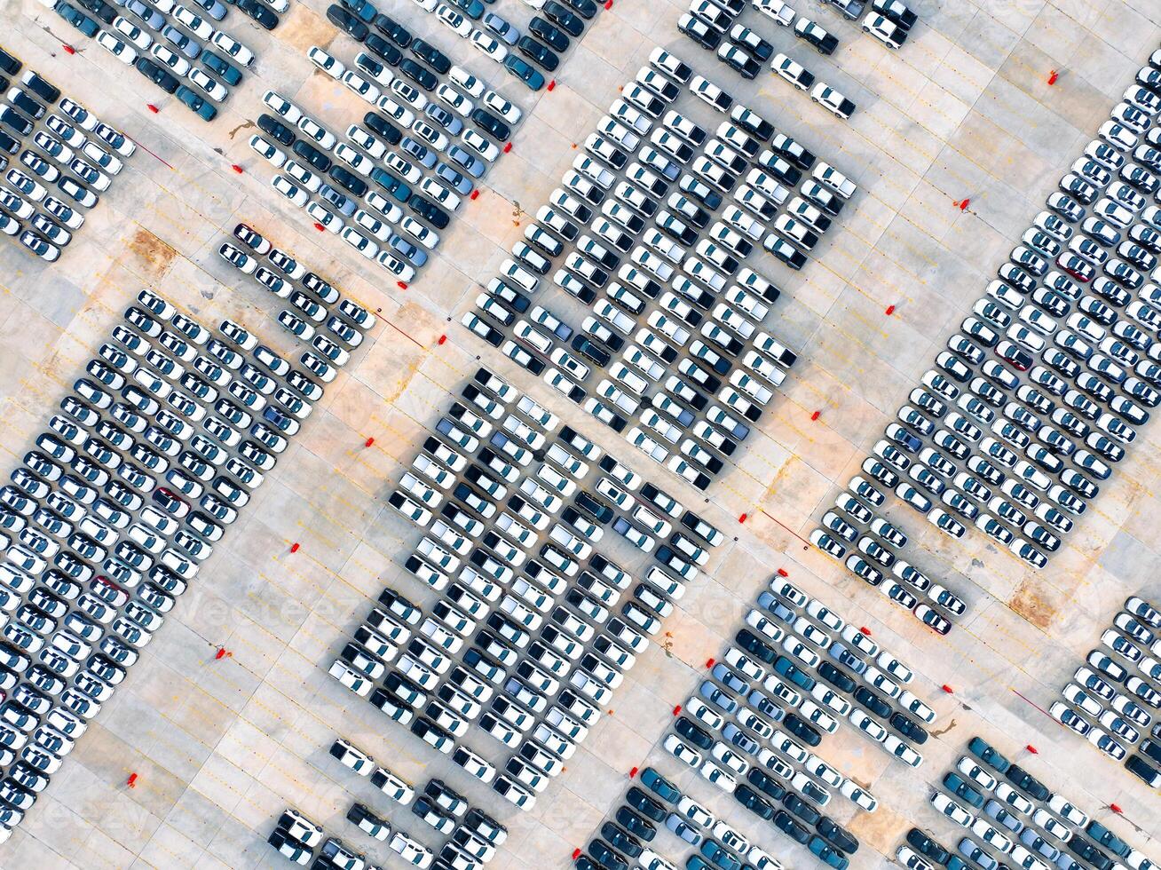 Aerial view of automotive logistics. Factory parking lot filled with rows of new cars. Modern vehicle production and distribution. Import or export operations at expansive port terminal facilities photo