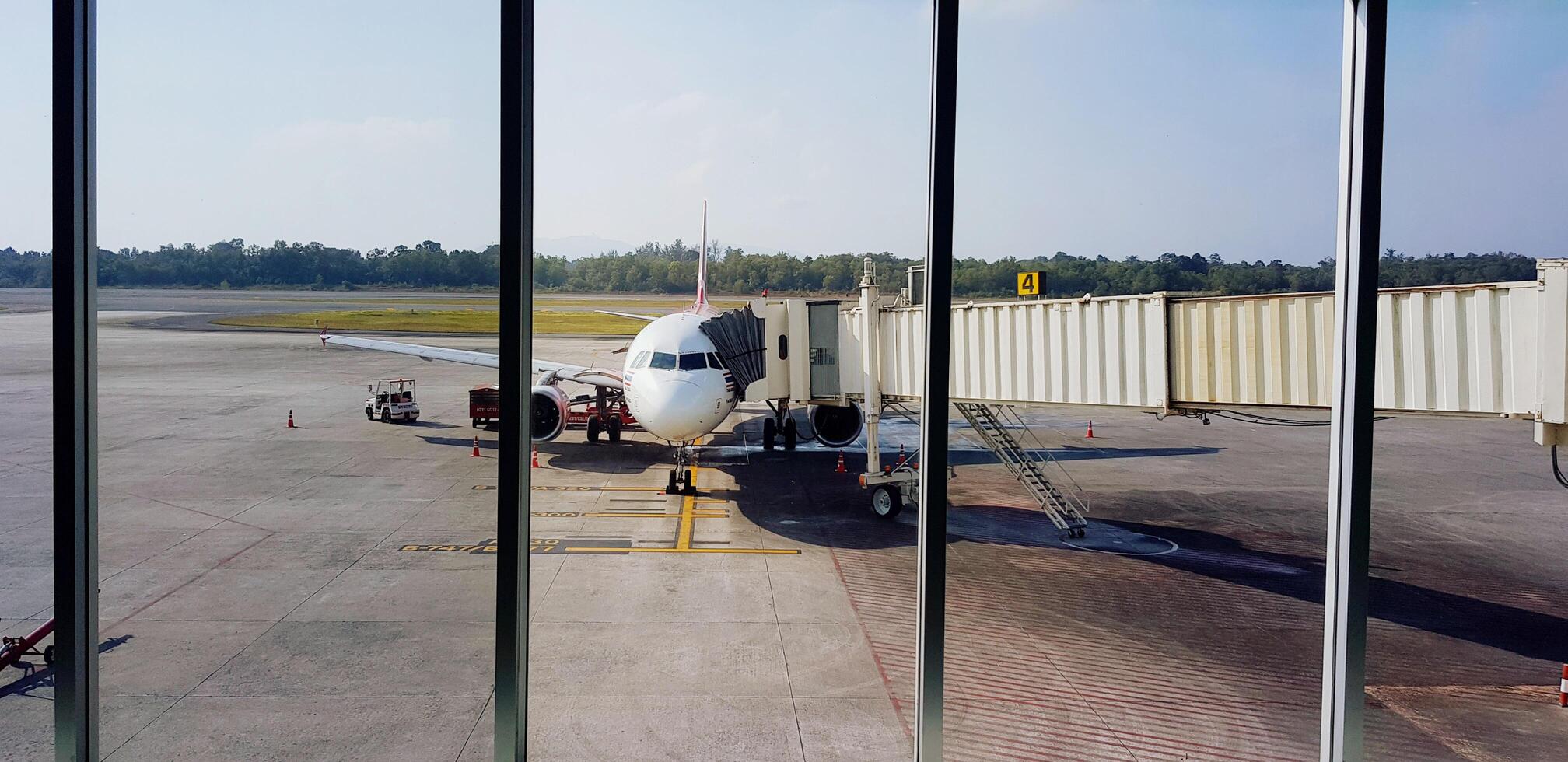 Songkhla, Thailand - May 22, 2024 Airplane parked and waiting for passenger get inside with blue sky and tree background at Hat Yai airport, Songkhla, Thailand. transportation and vehicle. photo