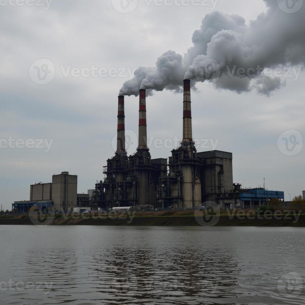 A polluted river surrounded by towering smokestacks from an industrial factory photo