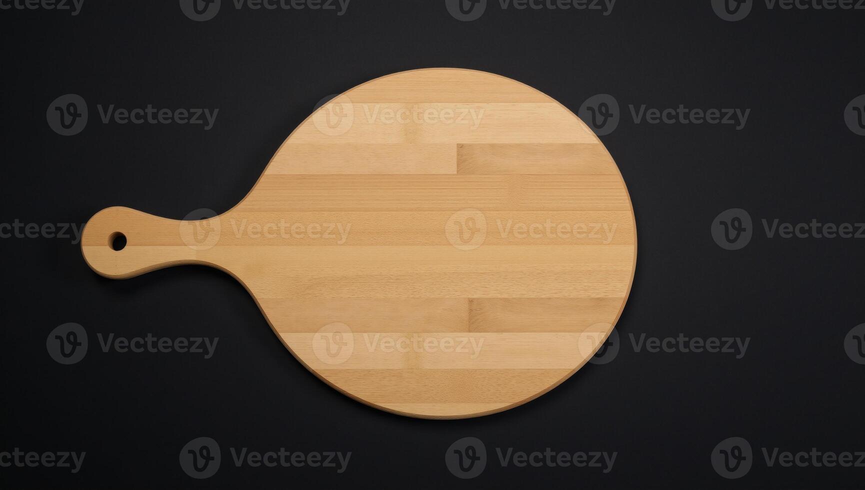 Round wooden chopping board with handle against a dark backdrop Flat Lay photo