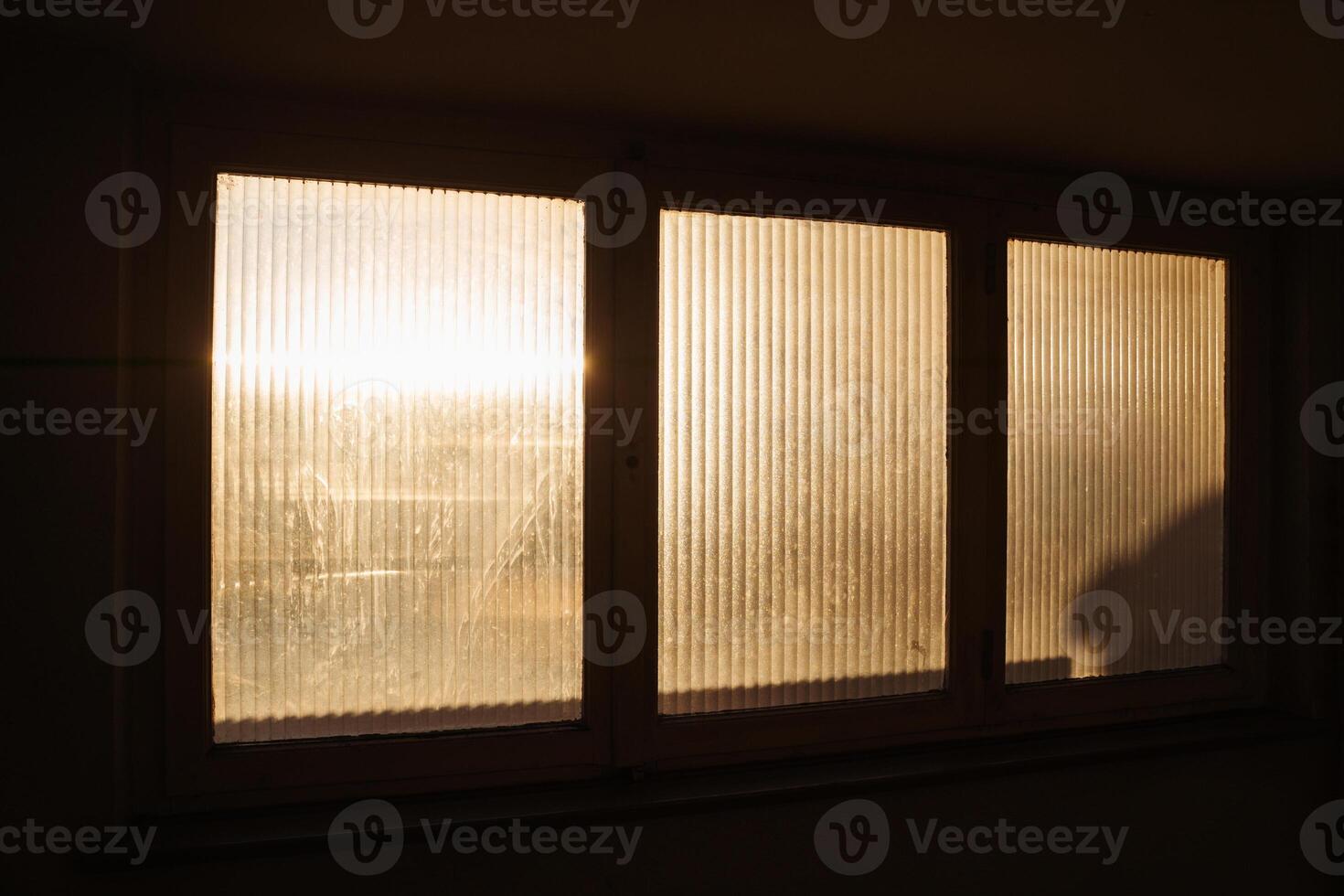 Warm morning sunlight filters through a frosted window, casting soft glows and shadows in apartment building. A serene depiction of peaceful beginnings and tranquil home environments. photo