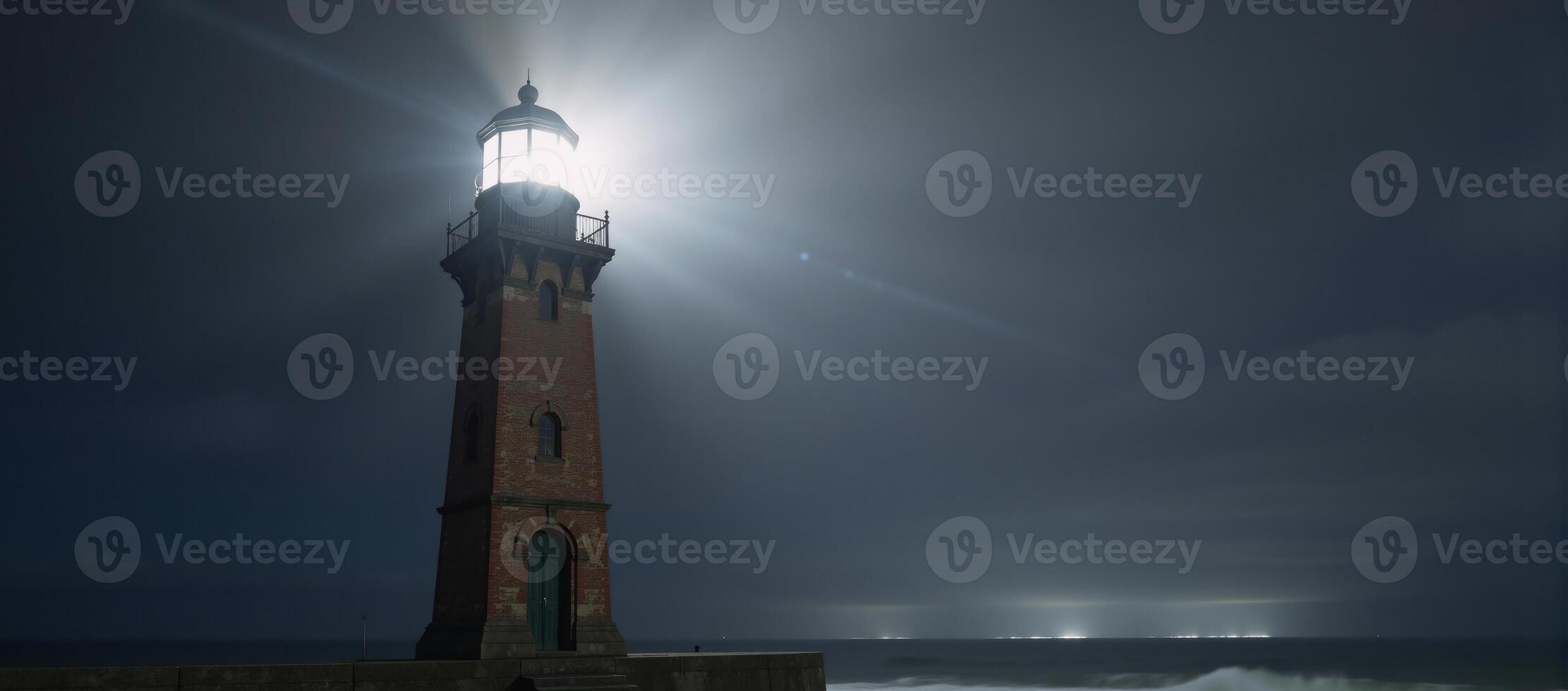 A lighthouse shines amidst foggy surrounds photo