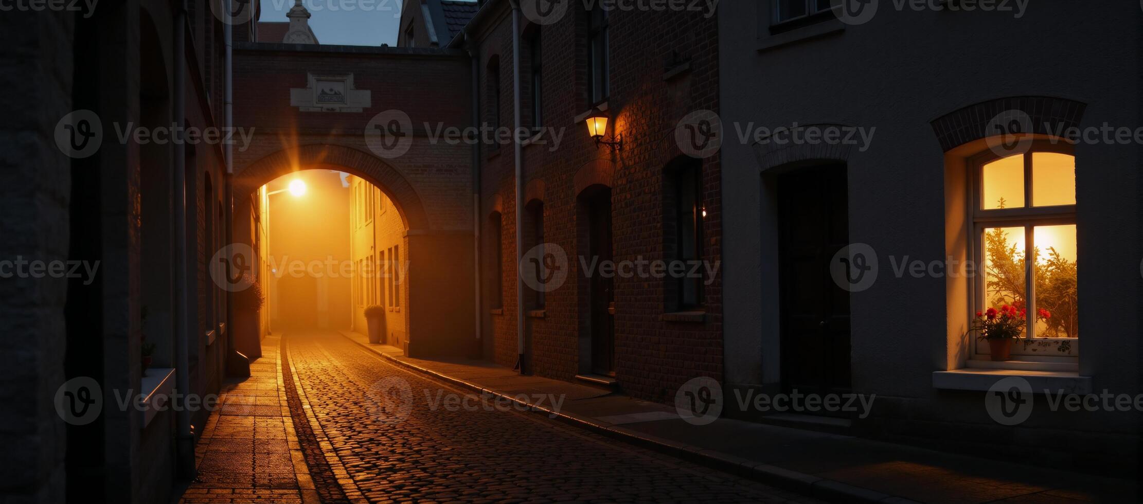 A nighttime scene of an old town street featuring fog and warm lights set in historic Bruges Belgium photo