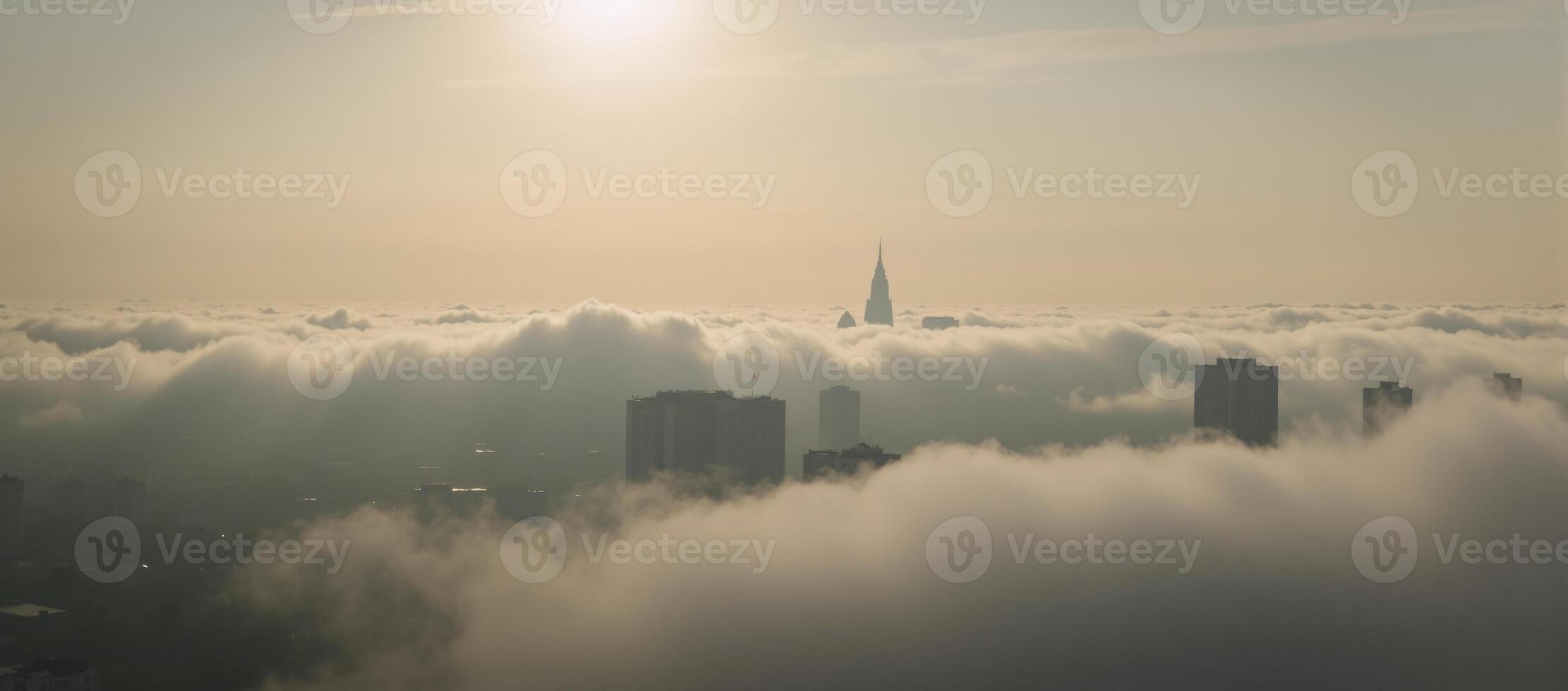 Sunrise over cityscape shrouded by dense fog photo