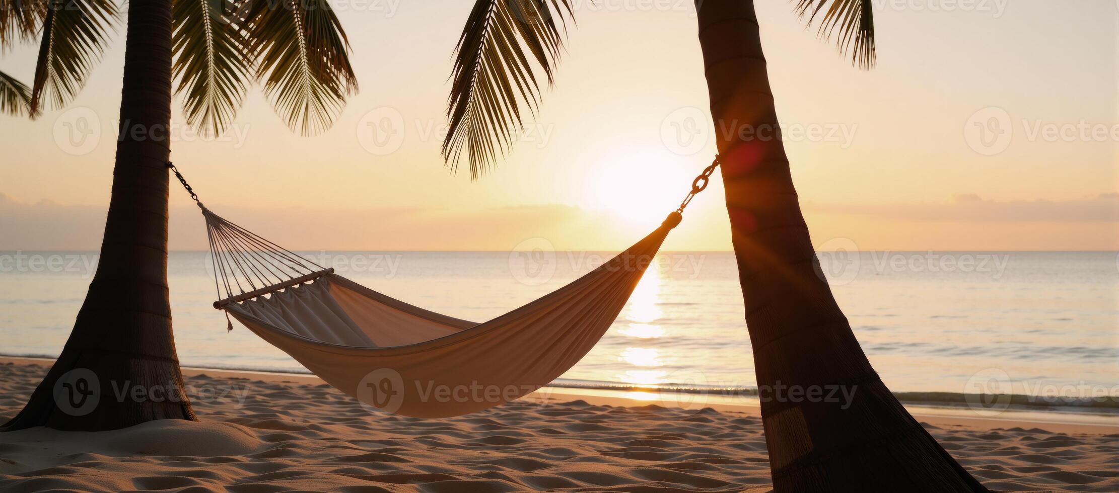 Hammock on a sunsetlit beach surrounded by palm trees photo