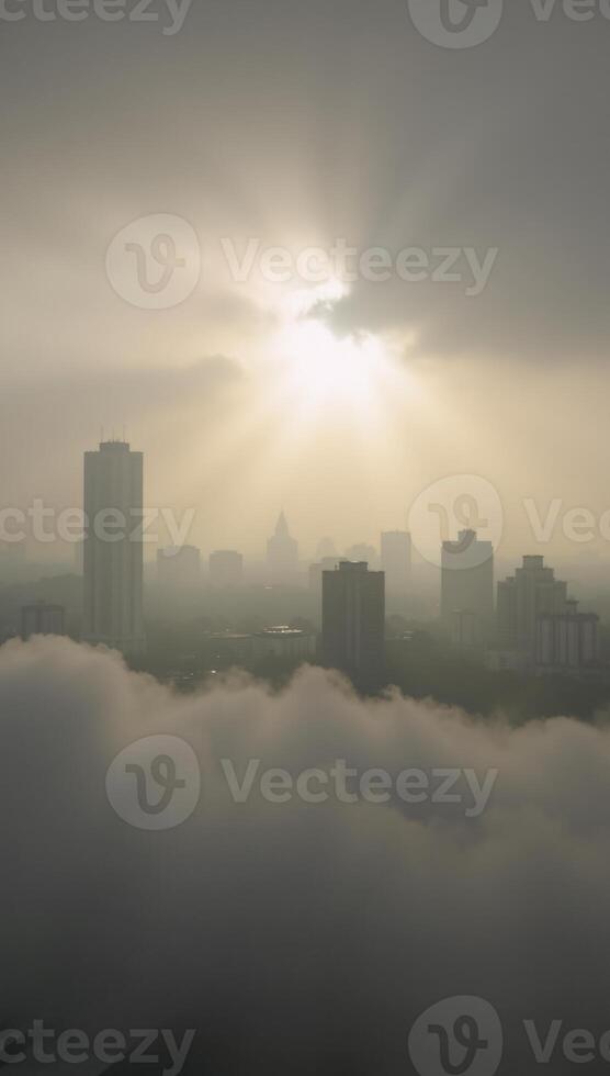 Sunrise over cityscape shrouded by dense fog photo