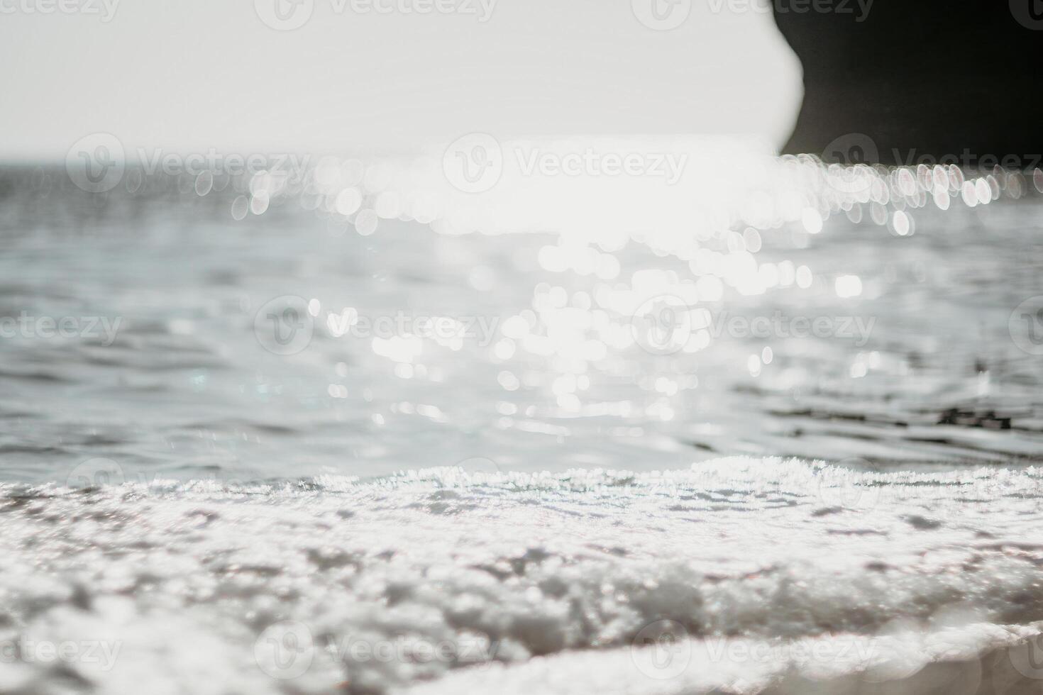 Abstract nature summer ocean sunset sea background. Small waves on water surface in motion blur with bokeh lights from sunrise. Holiday, vacation and recreational background concept. photo