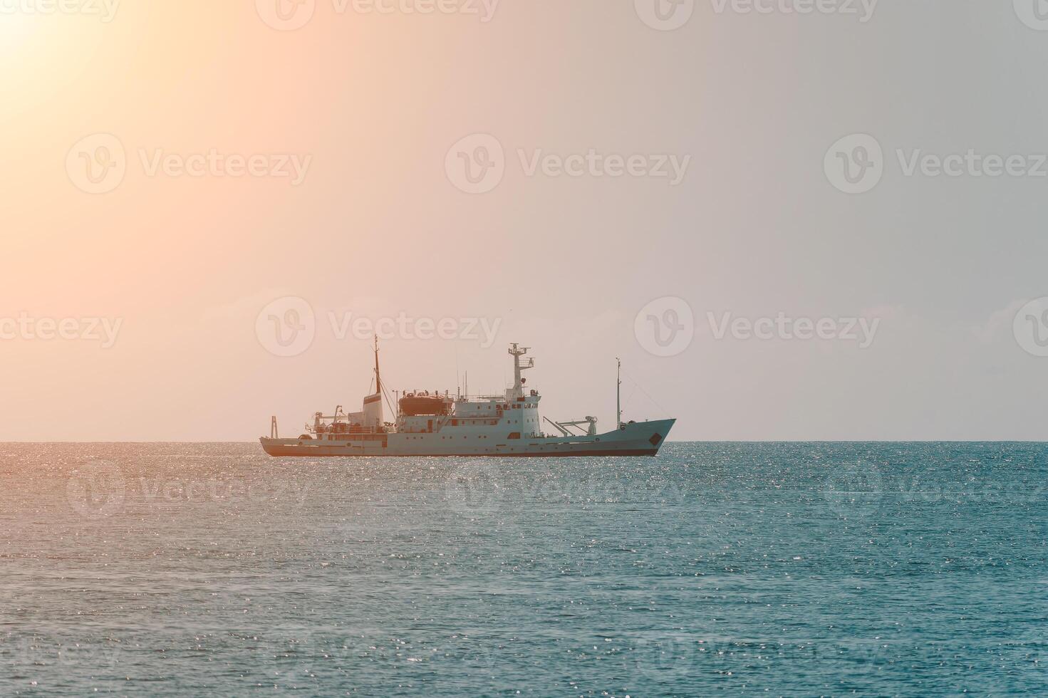 Ship, Sea, Sunset - A lone ship sails across the calm sea at sunset. photo