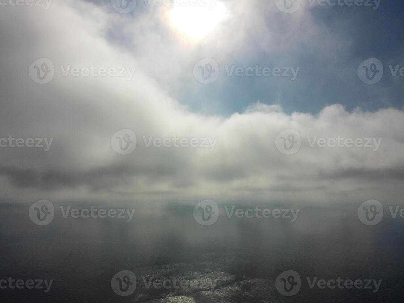 Aerial view. The drone flies over foggy and fluffy clouds. Blue sky sun and sea fog. Abstract aerial nature summer ocean sunset sea and sky background. Vacation, travel and holiday concept photo