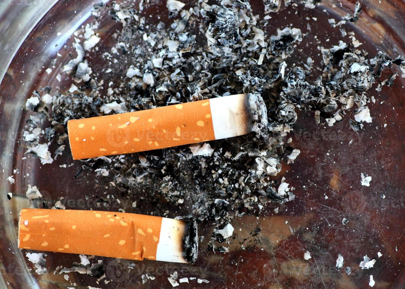 Close-Up of Cigarette Butts and Ash in an Ashtray Highlighting Smoking and Health Concerns photo