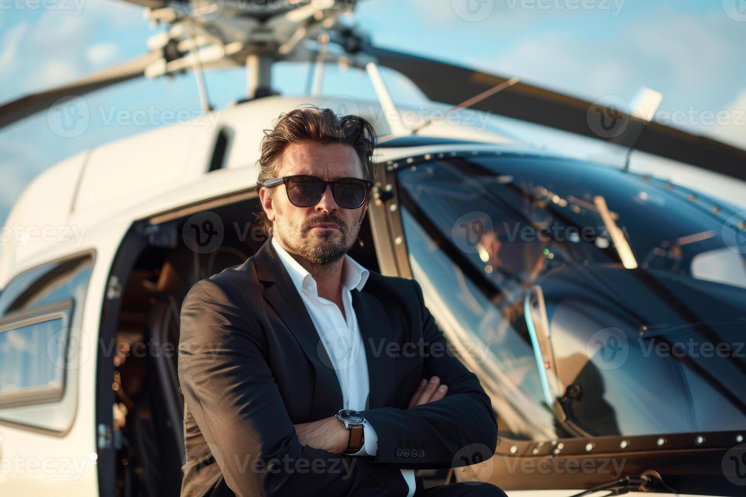 Confident businessman posing with arms crossed by private helicopter photo