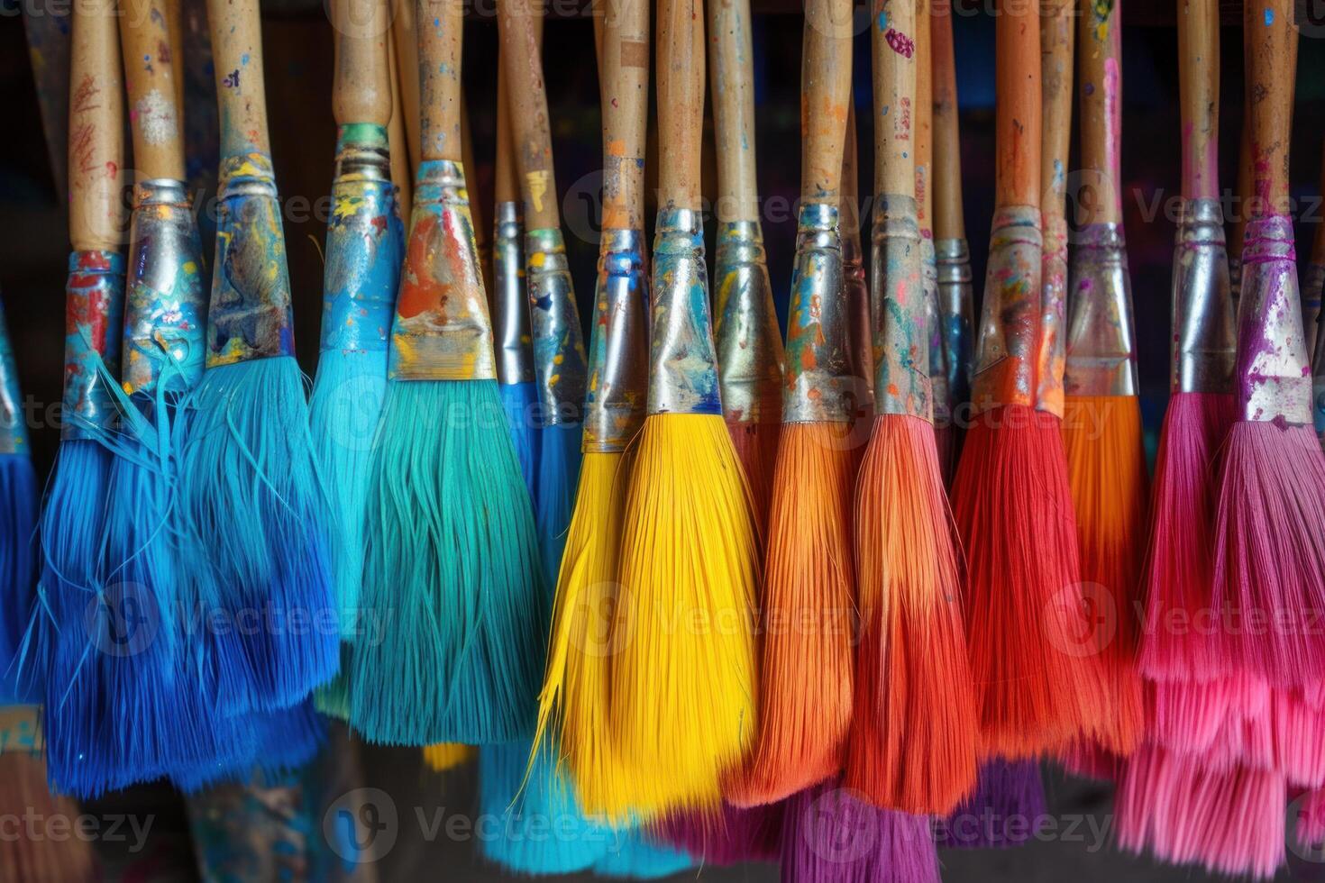 Colorful paintbrushes hanging and drying in an art studio photo