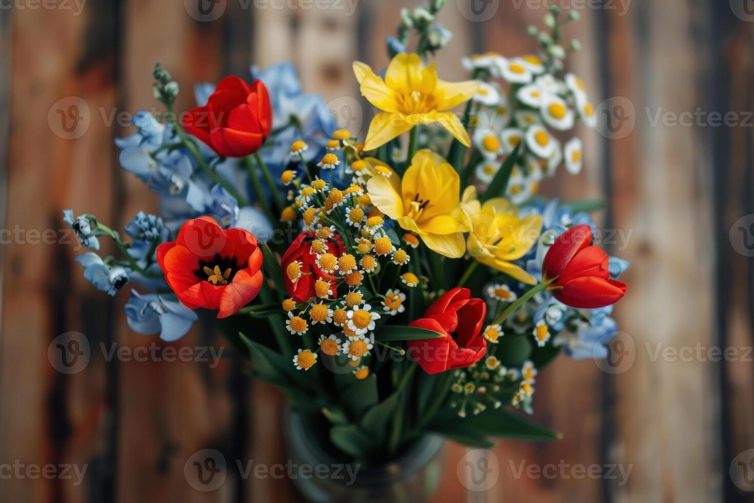 Beautiful colorful bouquet standing in a vase on wooden table photo