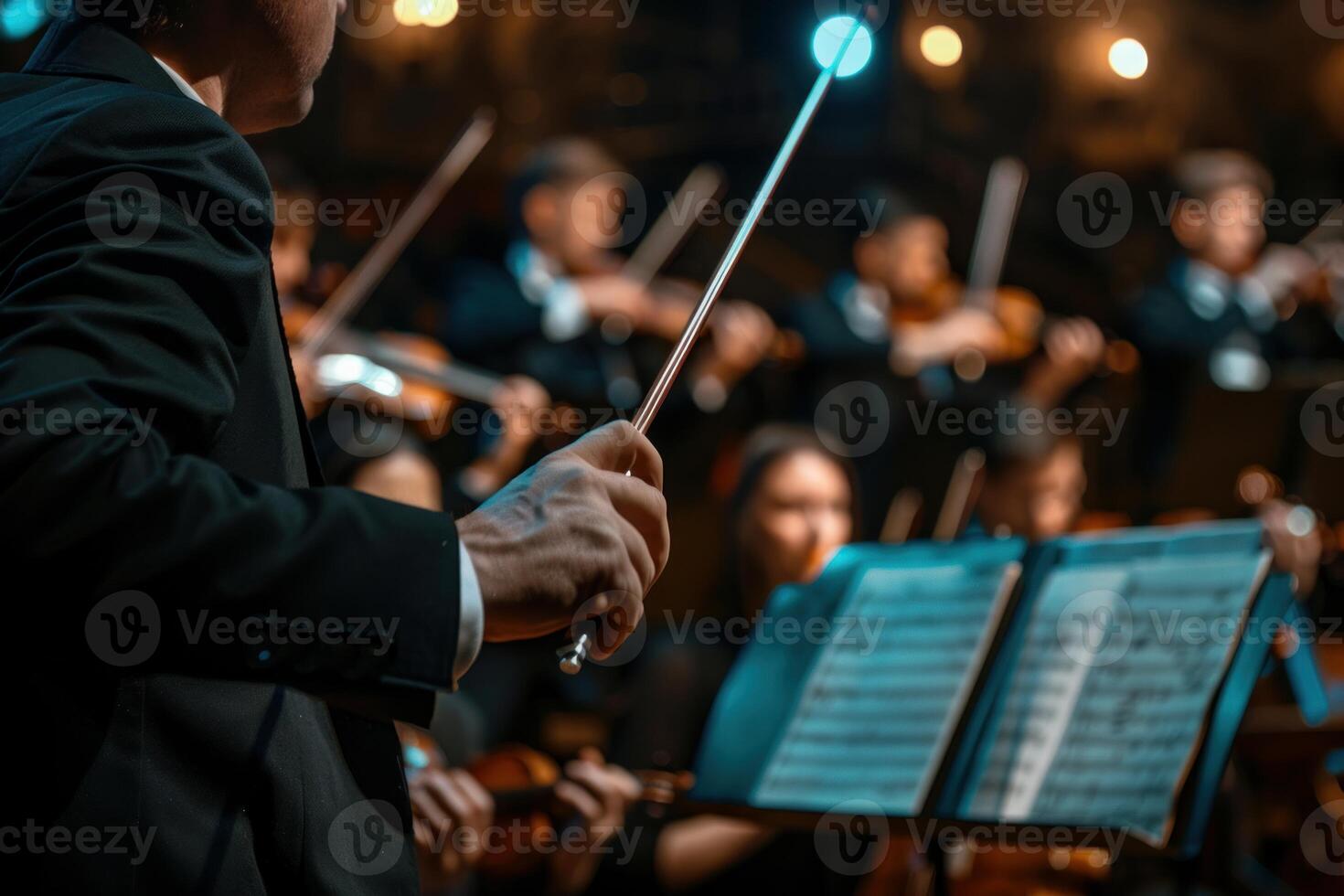 Orchestra conductor directing symphony orchestra with baton during concert photo