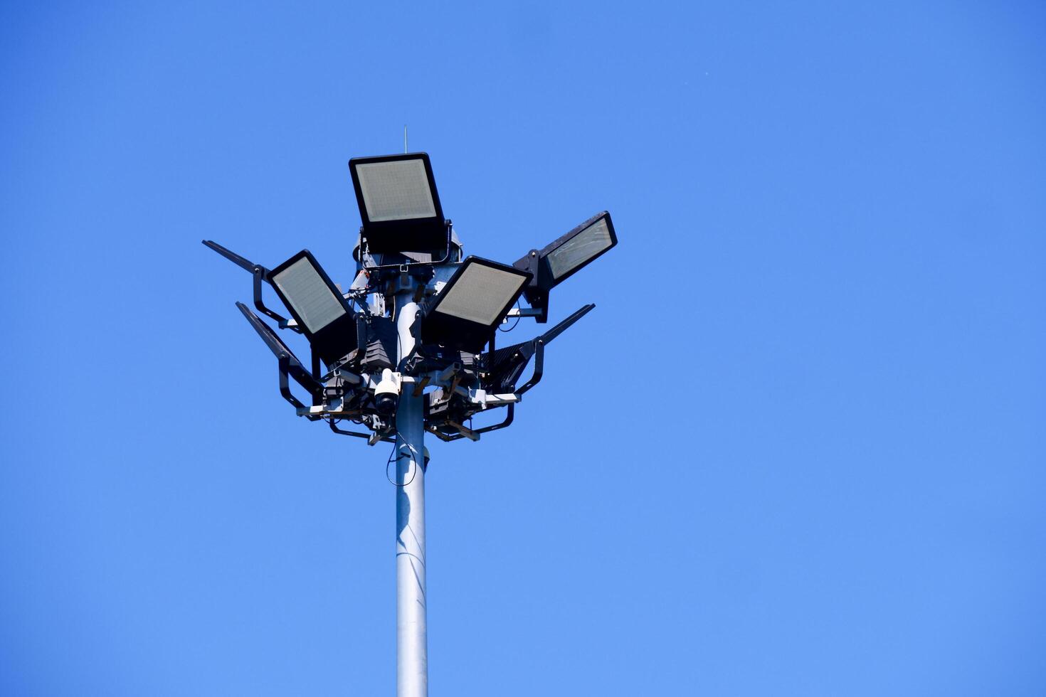 High-Powered Stadium Floodlights Against a Clear Blue Sky on a Bright Sunny Day photo