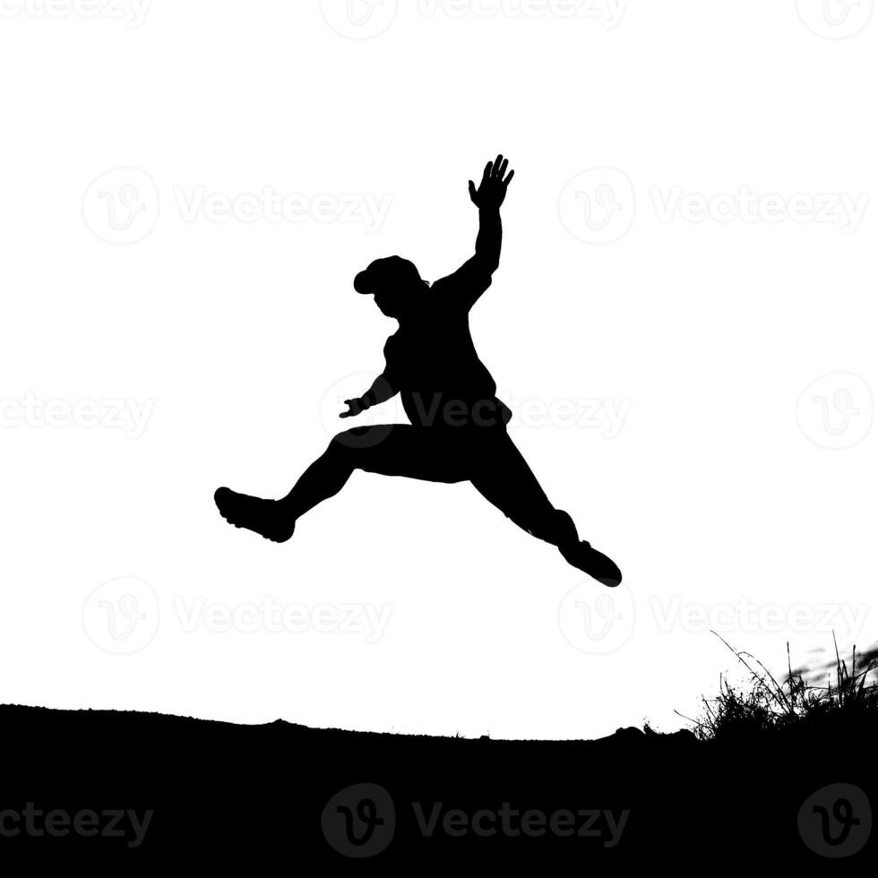 Silhouette of a Person Jumping Mid-Air Against a White Background in an Outdoor Setting photo