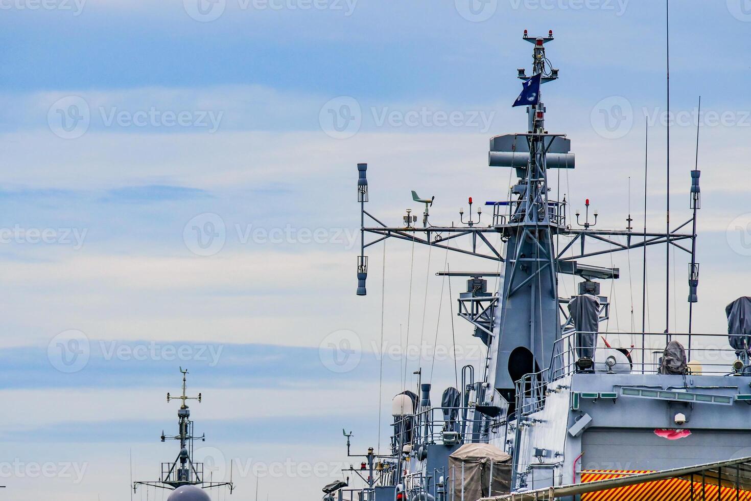 Naval Warships with Advanced Communication Equipment Docked at Harbor Under Clear Blue Sky photo