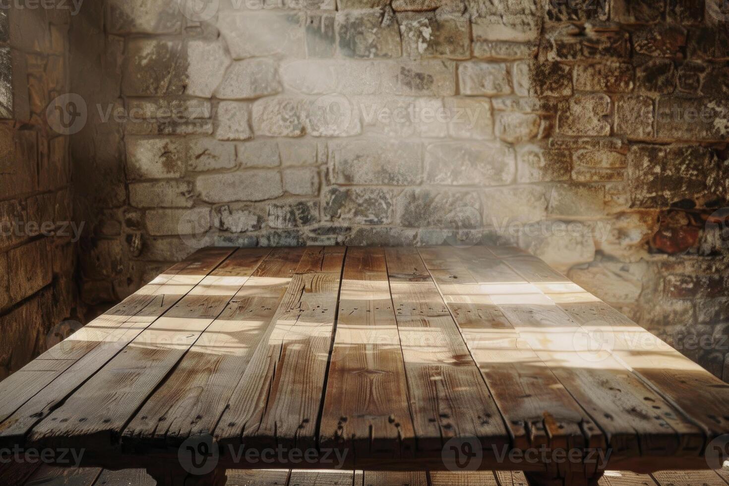 Sunlit rustic wooden table against stone wall photo