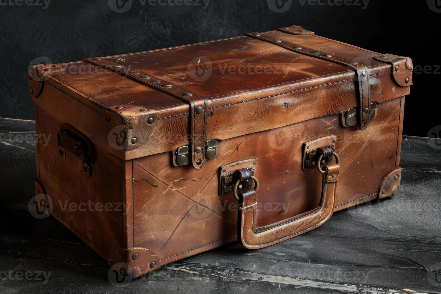 Old leather suitcase sitting on dark wooden floor photo