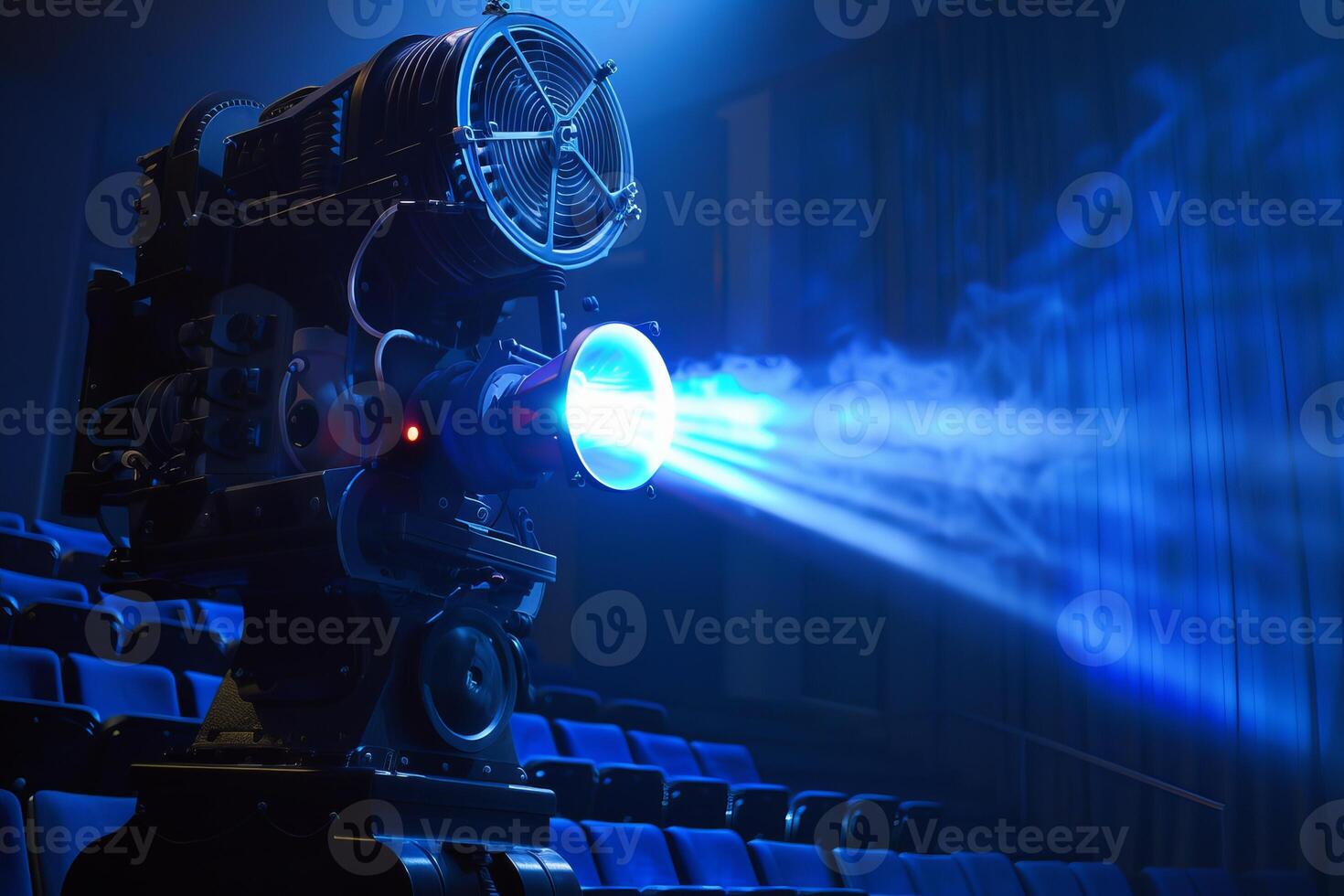 Vintage movie projector casting light beam in empty theater photo