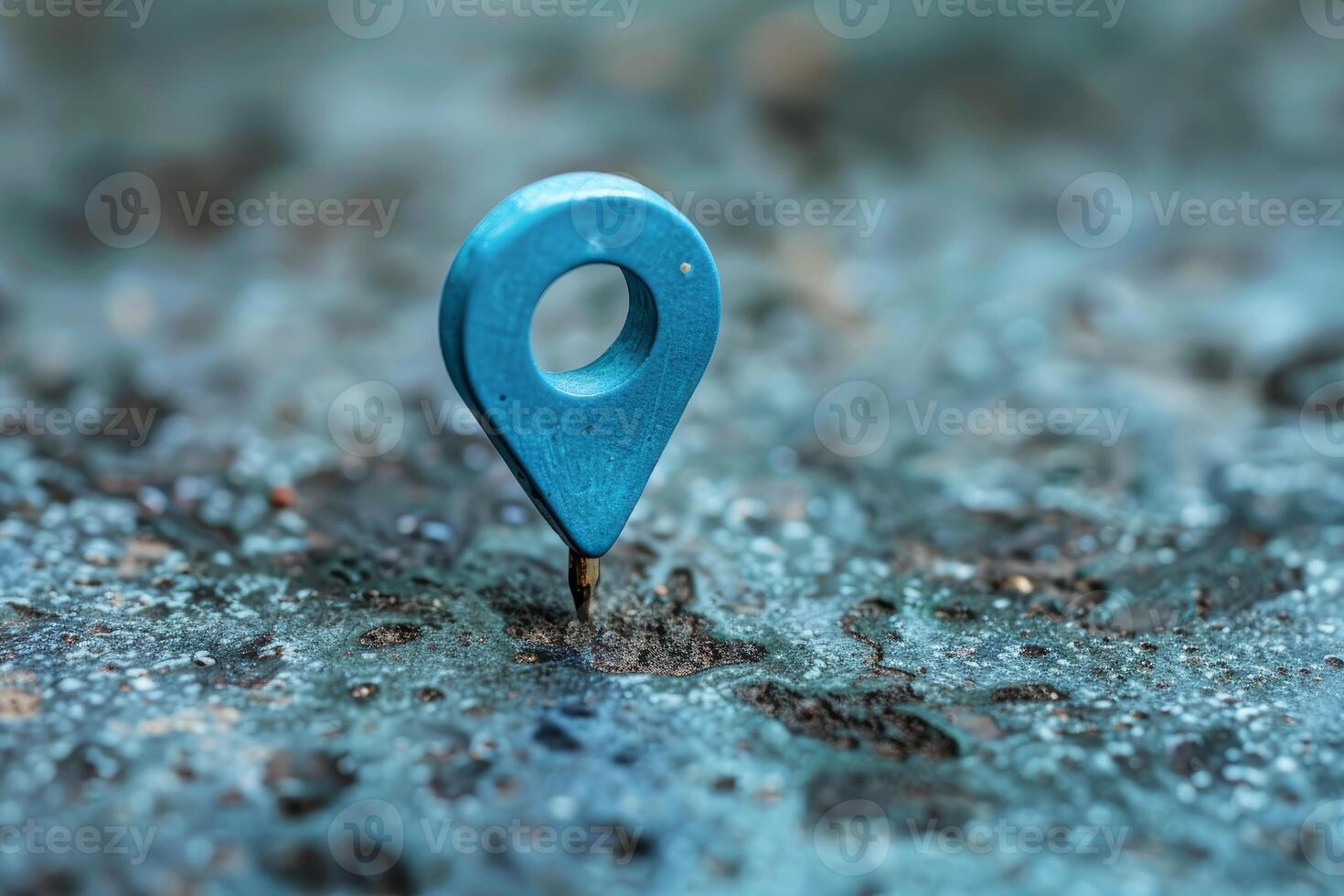 Blue location pin standing on rough stone surface photo