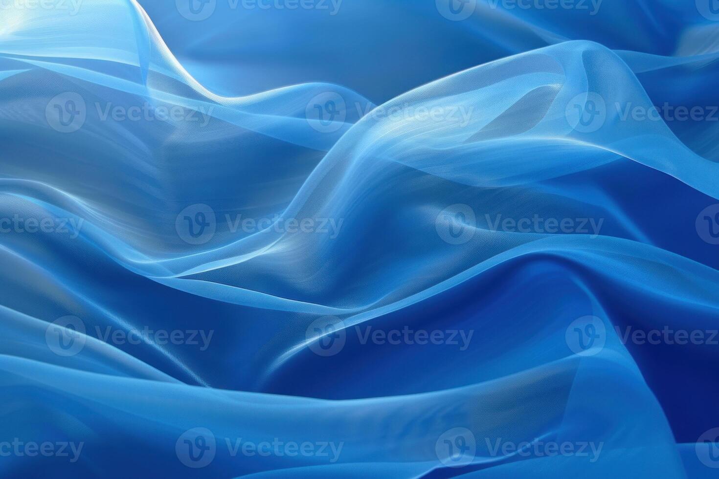 Blue transparent chiffon fabric is flowing down creating smooth elegant folds photo