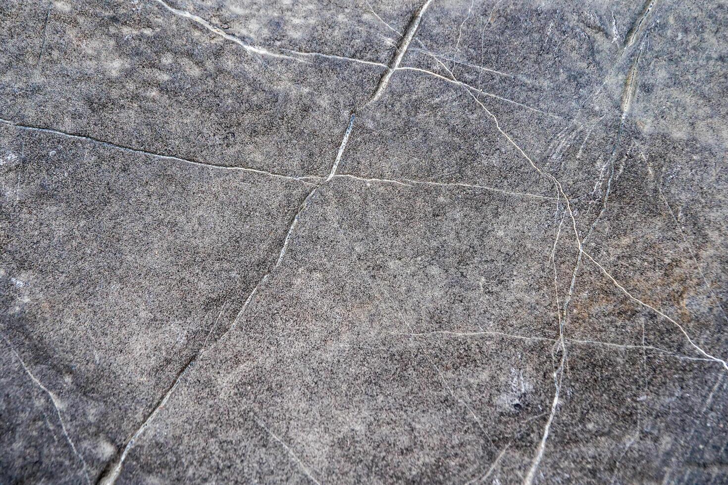 A close up of a stone surface with cracks photo