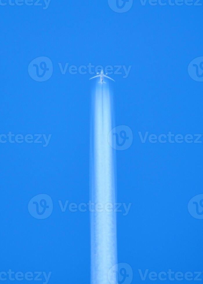 Airplane Flying High in Clear Blue Sky with Contrail - Minimalist Aerial Photography photo