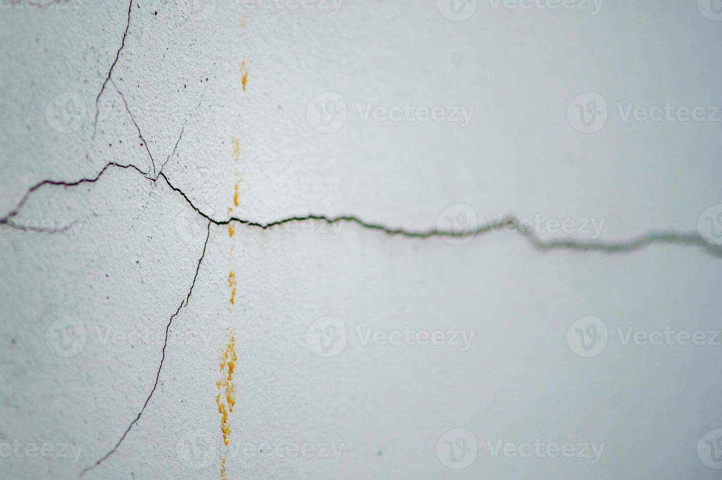 A crack in the wall with a yellow paint photo