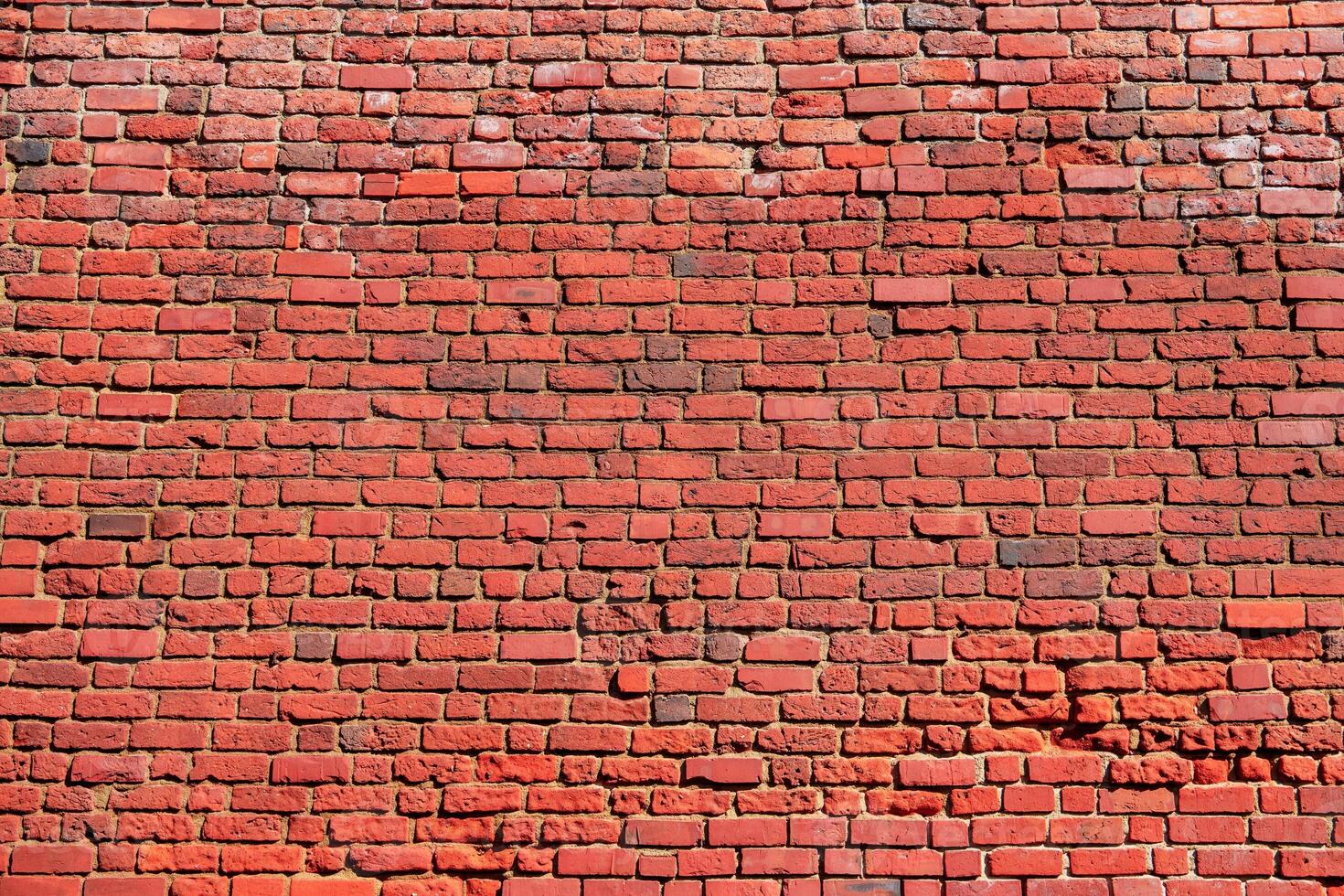The image shows a red brick wall texture background. The retro-style grunge urban backdrop is perfect for design and can be used as a mockup for text placement. It is isolated on a color background. photo