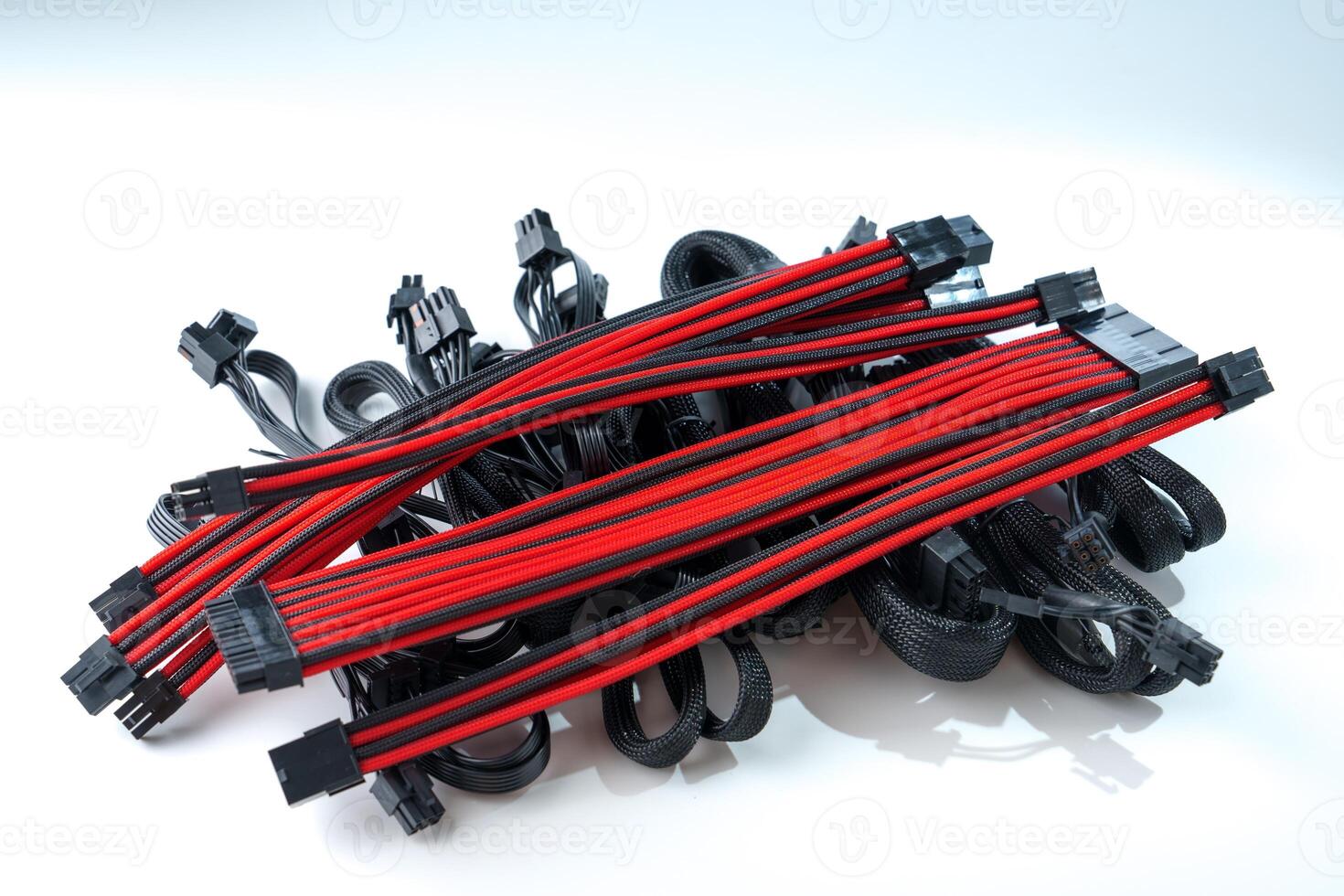 A black and red computer cable isolated on a white background. The cable is made up of multiple wires, each covered in a red and black sleeve. The cable is used to connect a computer to a power source. photo