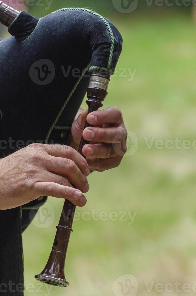 A person playing a bagpipe in the grass photo