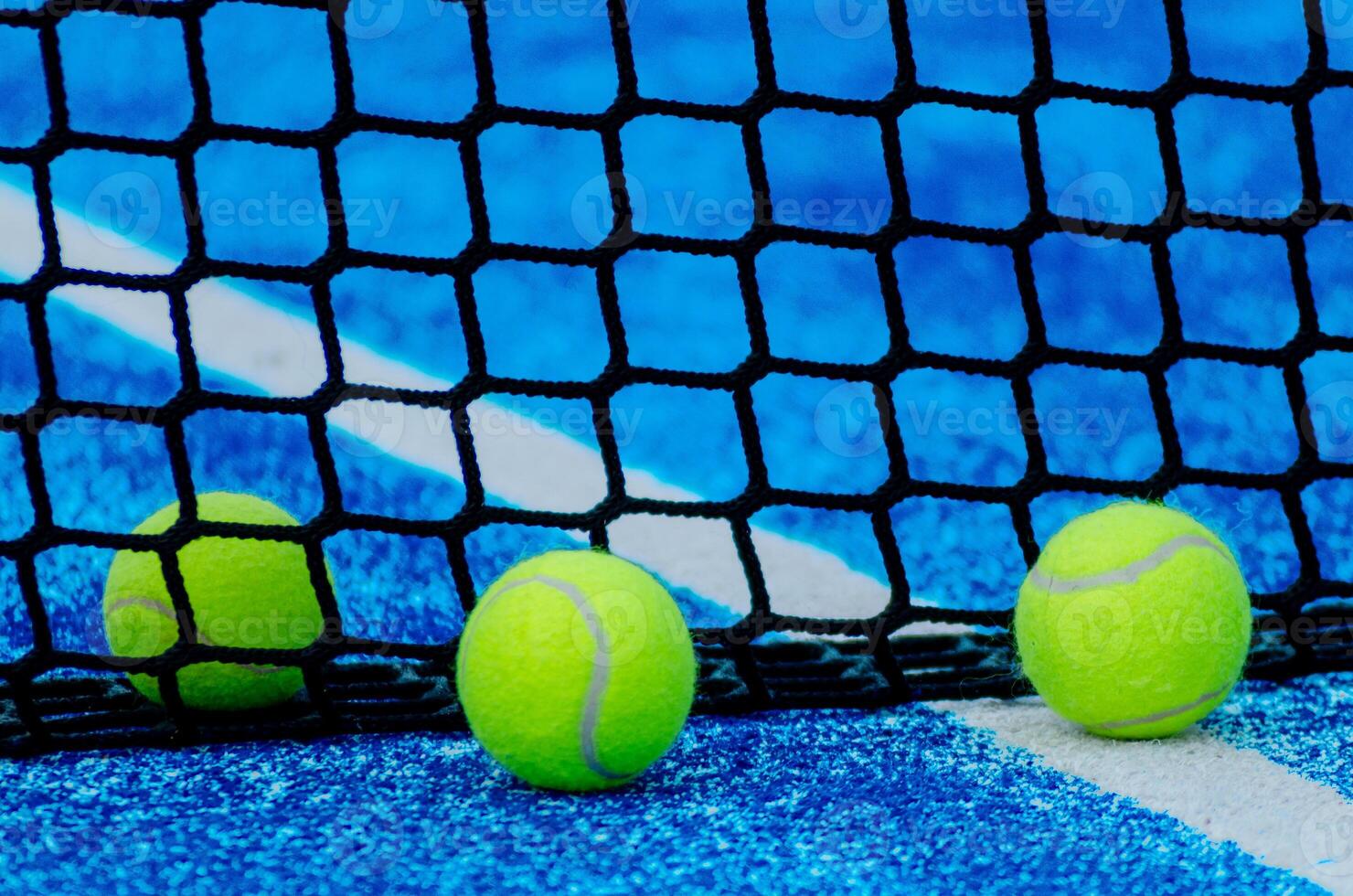 Three paddle tennis ball near the net photo